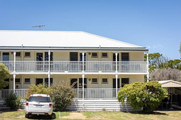 Motel wing with balconies and coastal gardens